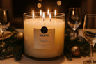 AEMBR Juletid candle with multiple flames on a festive holiday table with glassware and pine branches.