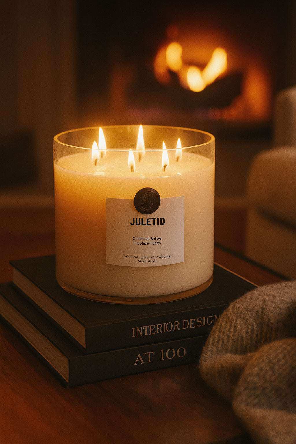 AEMBR Juletid candle with multiple flames on stacked books by a cozy fireplace setting