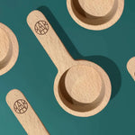 AEMBR wooden laundry scoops on green background, eco-friendly non-toxic home accessory