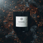 AEMBR Old Fashioned scented candle with smoked whiskey and vanilla, surrounded by smoke.