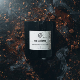 Black candle labeled 'Old Fashioned' with smoke effects on a dark background