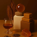 Amber-toned home fragrance display with glass, cubes, botanicals, and clean ingredients by AEMBR.