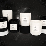 AEMBR non-toxic black and white candles with labels on a starry night background.