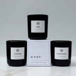 AEMBR luxury coconut wax candles in black jars with Tuxedo, Old Fashioned, and Dry Gin & Cypress scents.